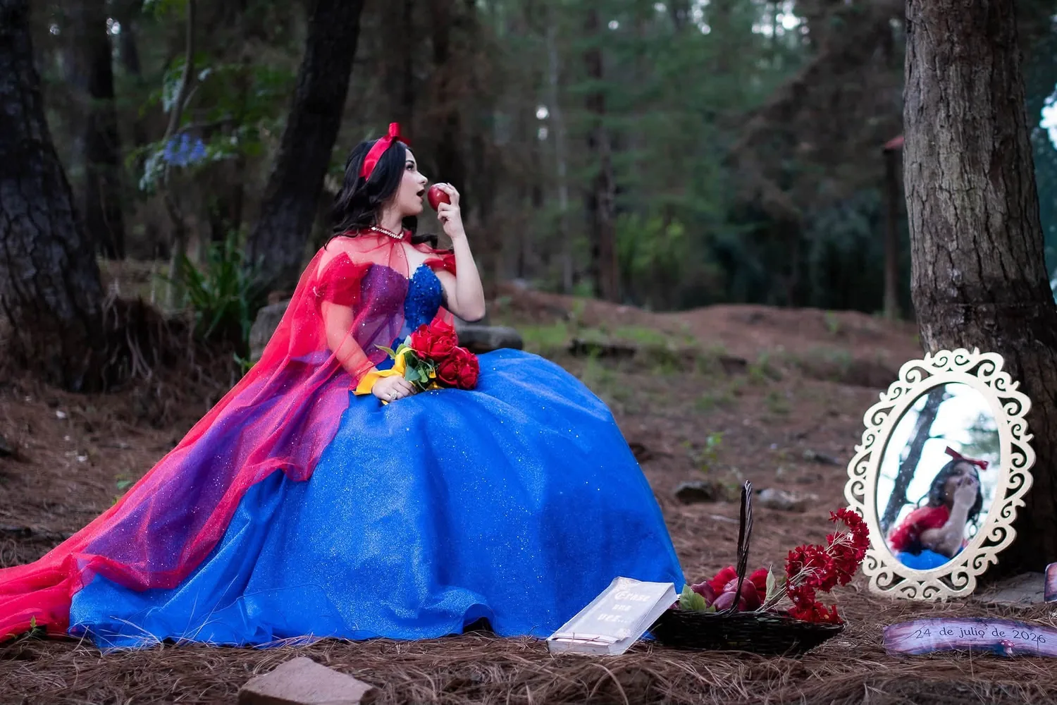 Camila con capa roja, vestido azul y rosas en el bosque